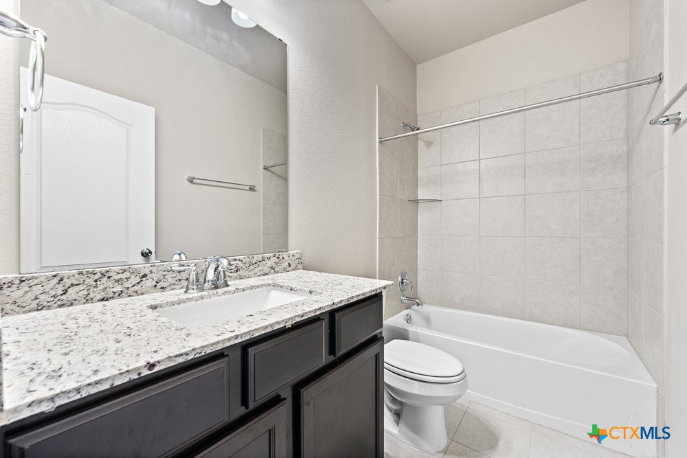 1028 Coriander Road Temple, TX 76501 - Photo 20 of 23 a bathroom with a granite countertop sink a toilet and shower