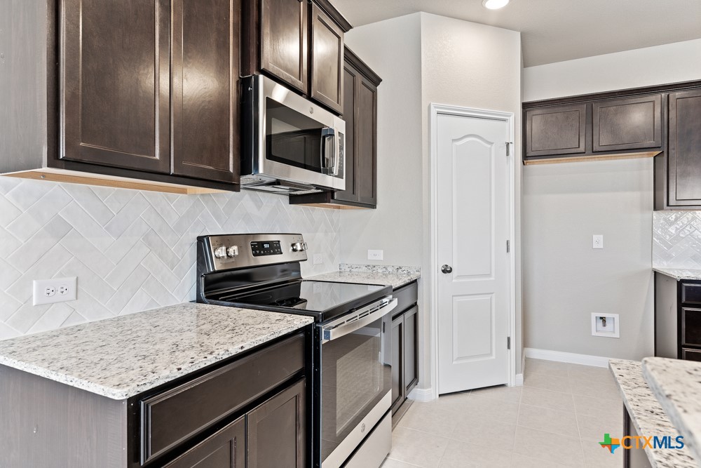 1028 Coriander Road Temple, TX 76501 - Photo 4 of 23 a kitchen with stainless steel appliances granite countertop a stove microwave and refrigerator