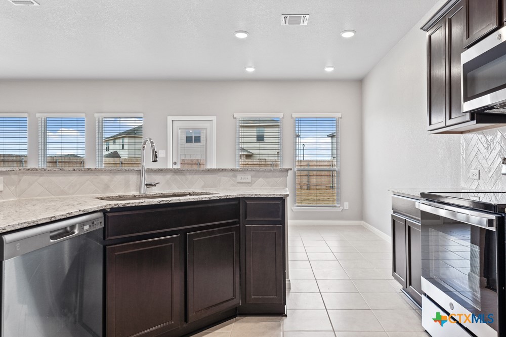 1028 Coriander Road Temple, TX 76501 - Photo 5 of 23 a kitchen with a sink stove and cabinets