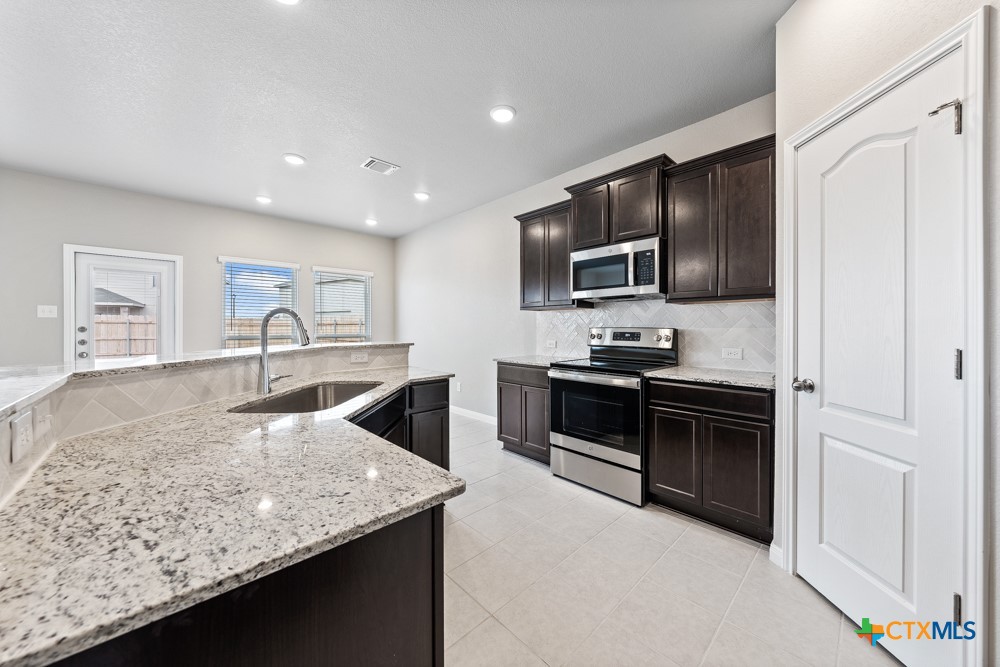 1028 Coriander Road Temple, TX 76501 - Photo 6 of 23 a kitchen with stainless steel appliances granite countertop a sink dishwasher stove and refrigerator