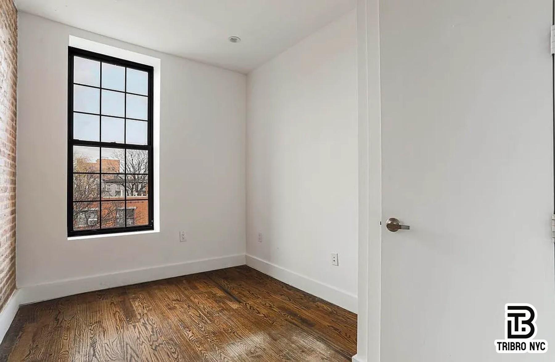 558 Kosciuszko Street, Unit 2R Brooklyn, NY 11221 - Photo 6 of 7 a view of an empty room with wooden floor and a window