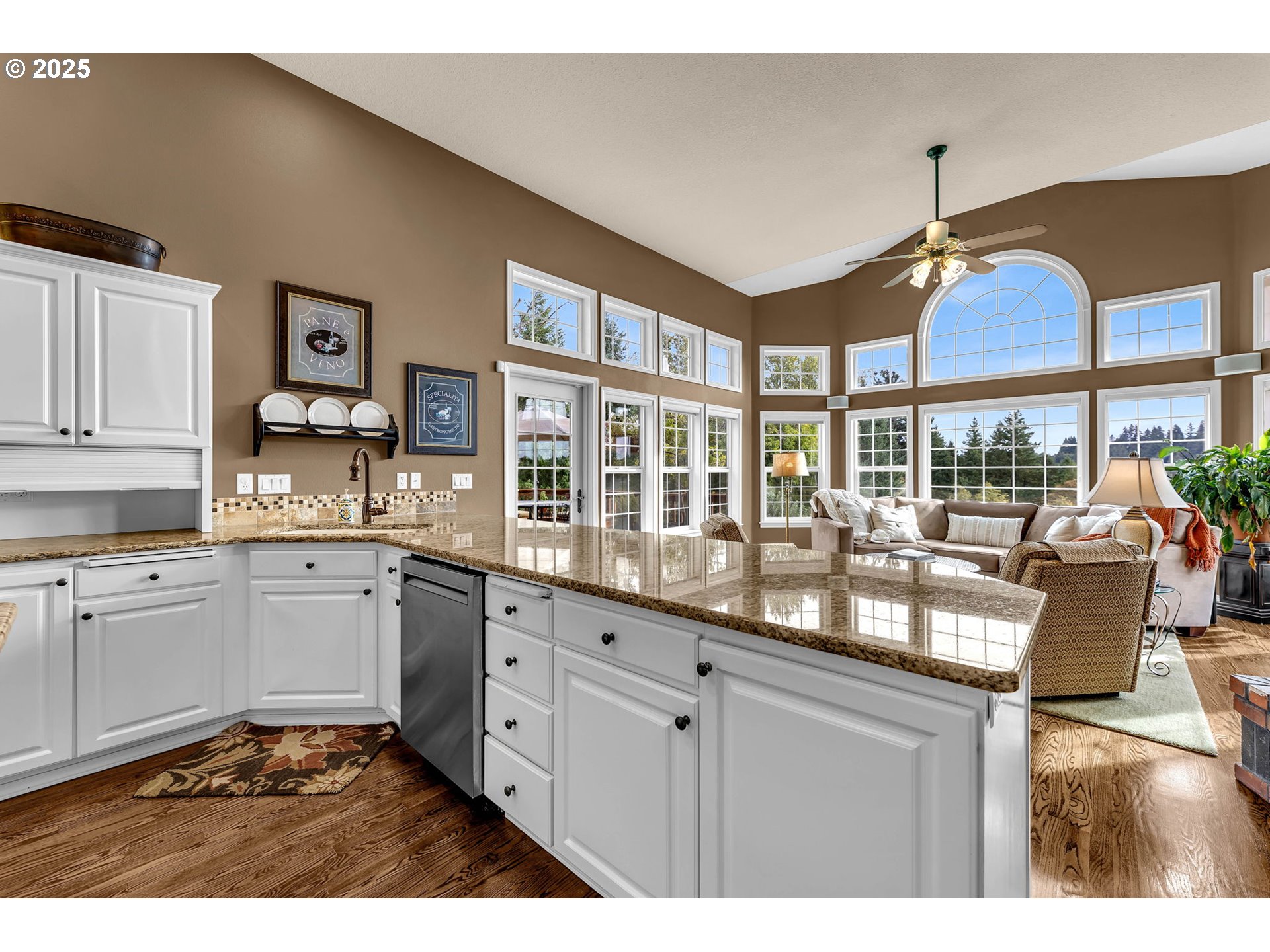 3901 Northwest 150th Circle Vancouver, WA 98685 - Photo 13 of 48 a kitchen with granite countertop a stove a sink and white cabinets with wooden floor