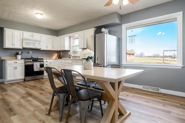 a kitchen with granite countertop white cabinets sink and stainless steel appliances
