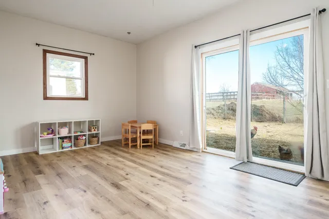 a view of a big room with wooden floor and windows