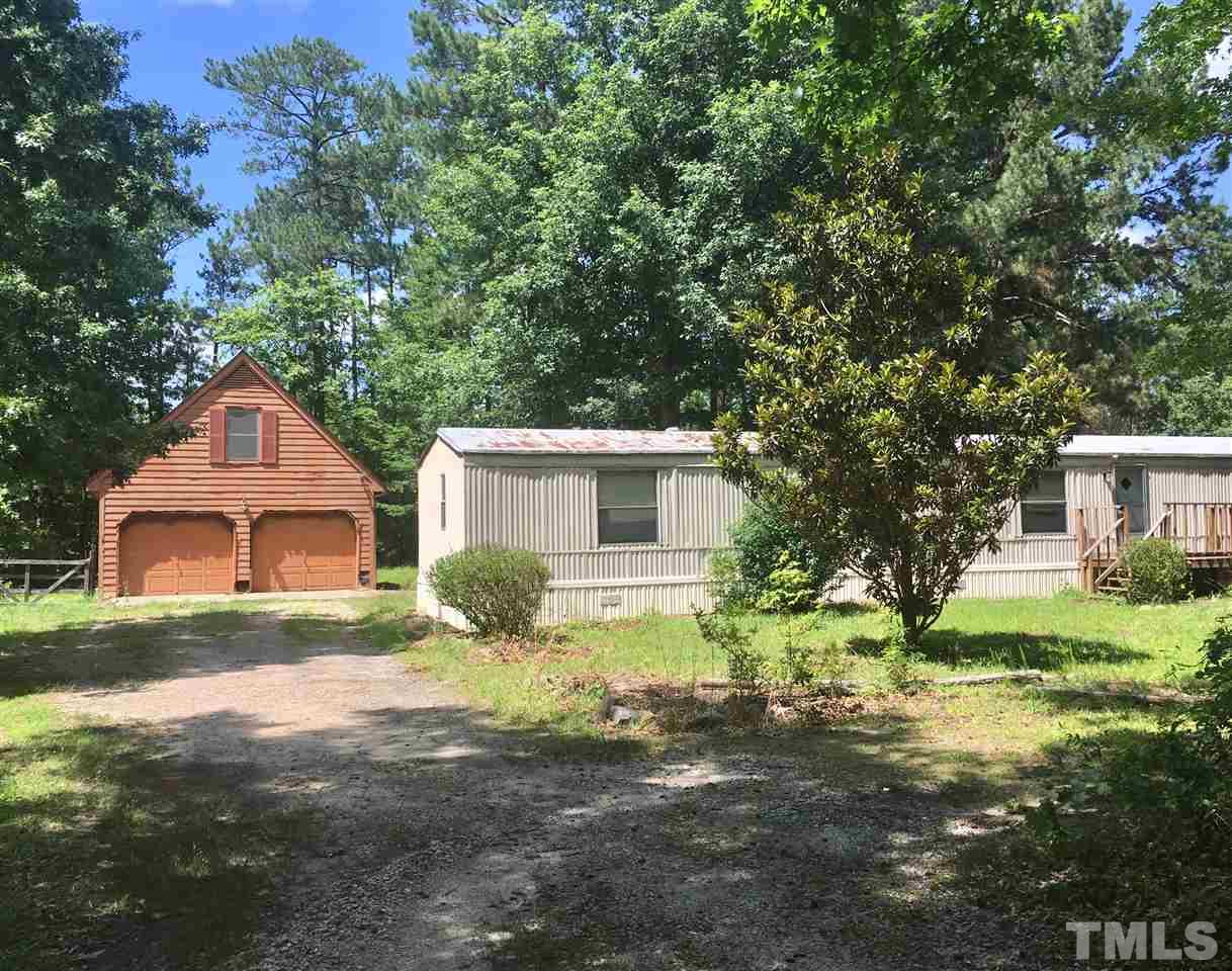 1612 Ridge Road Zebulon, NC 27597 - Photo 1 of 17 a front view of a house with a yard and garage
