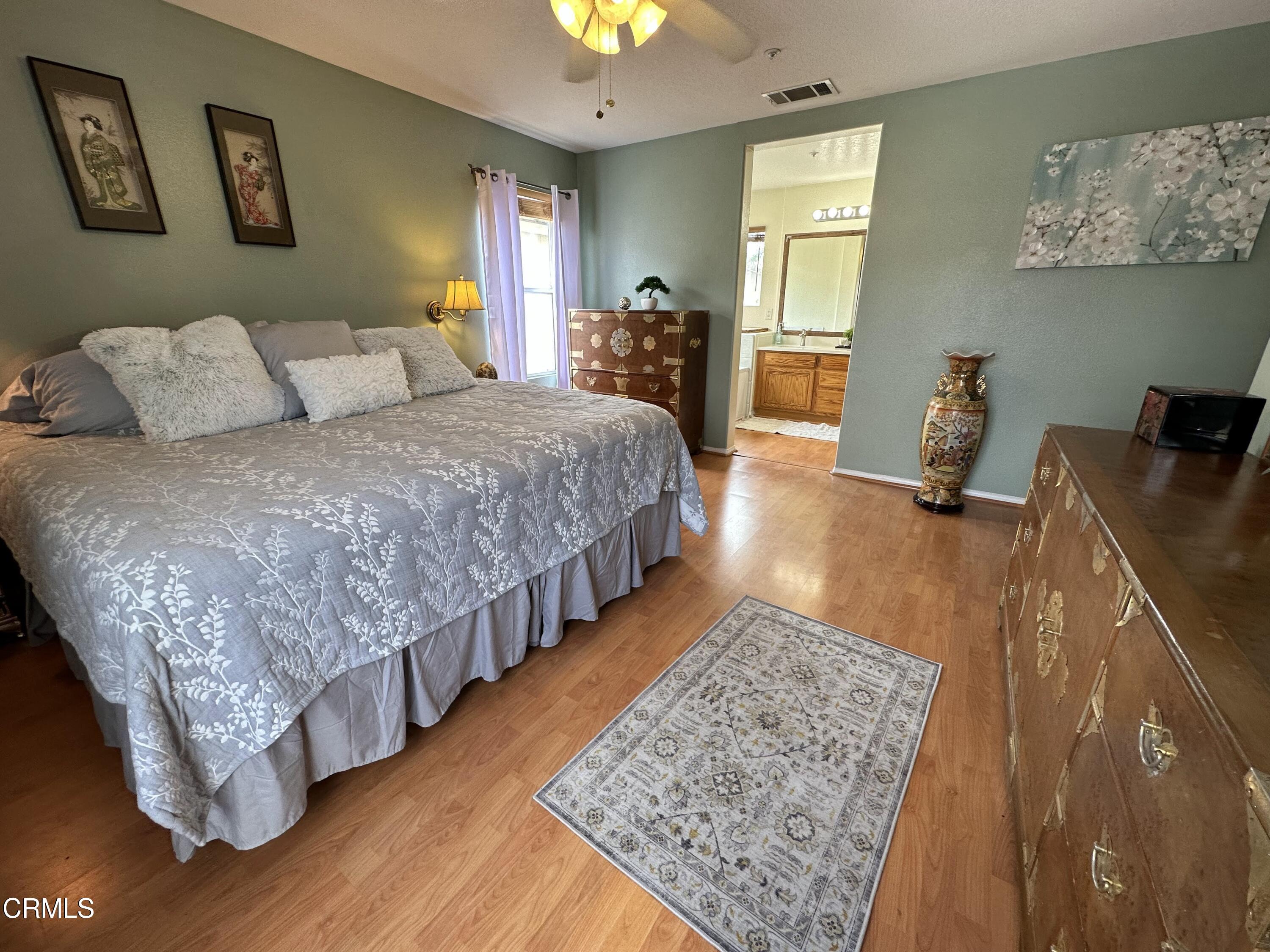 803 Noontide Way Oxnard, CA 93035 - Photo 13 of 26 a bedroom with a bed and wooden floor