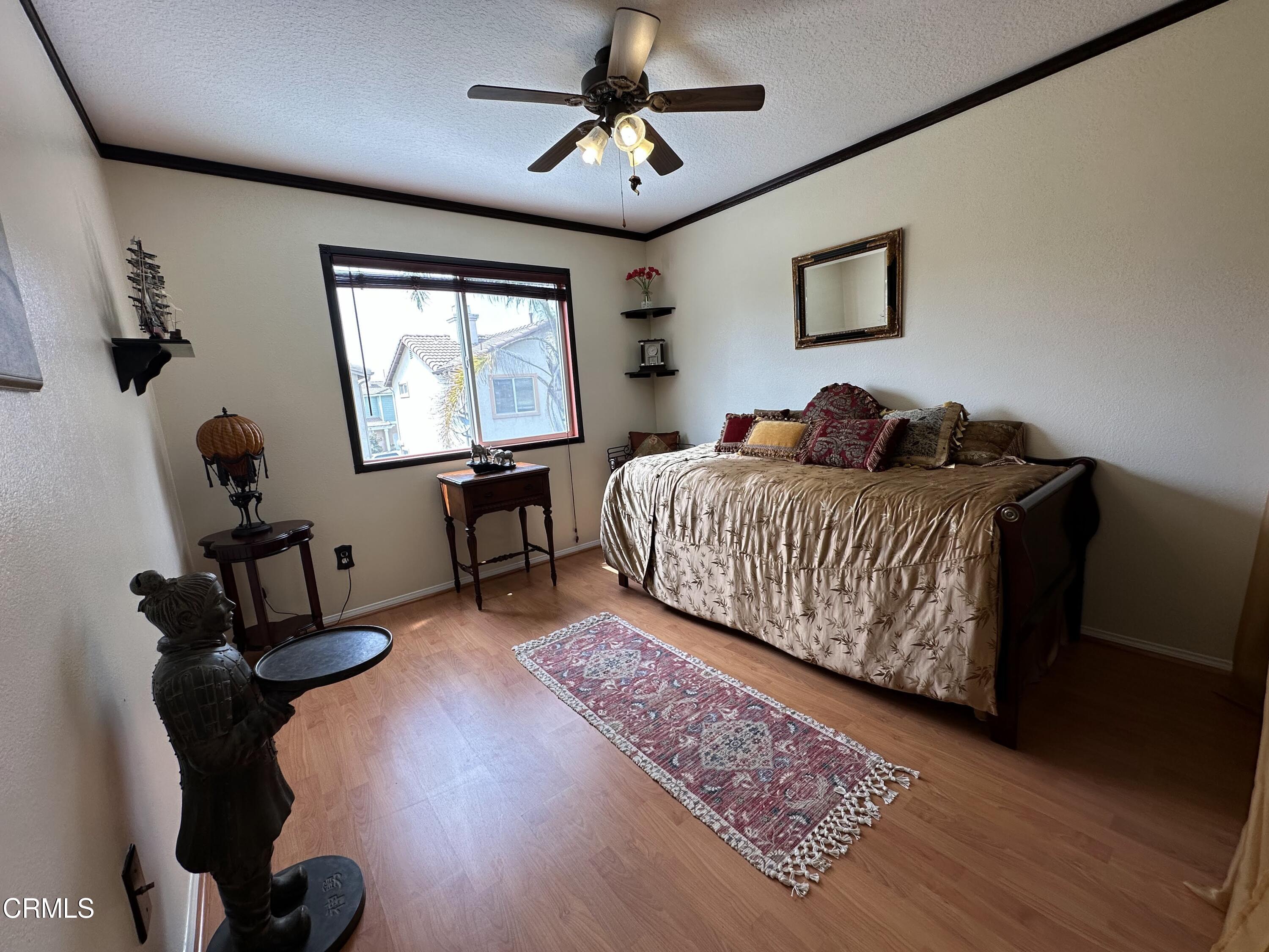 803 Noontide Way Oxnard, CA 93035 - Photo 20 of 26 a living room with a bed furniture chandelier and a window