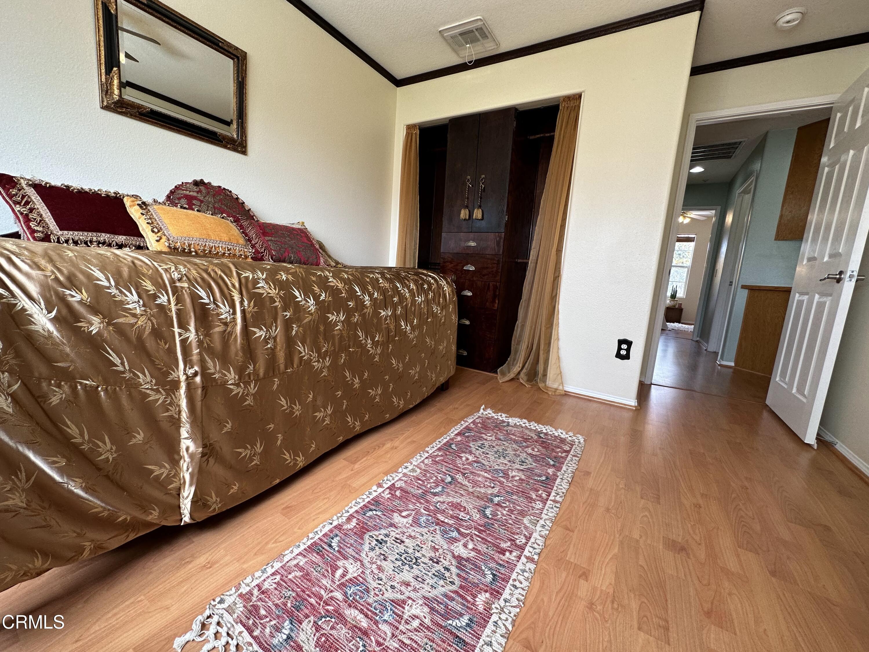 803 Noontide Way Oxnard, CA 93035 - Photo 21 of 26 a bedroom with a bed and wooden floor