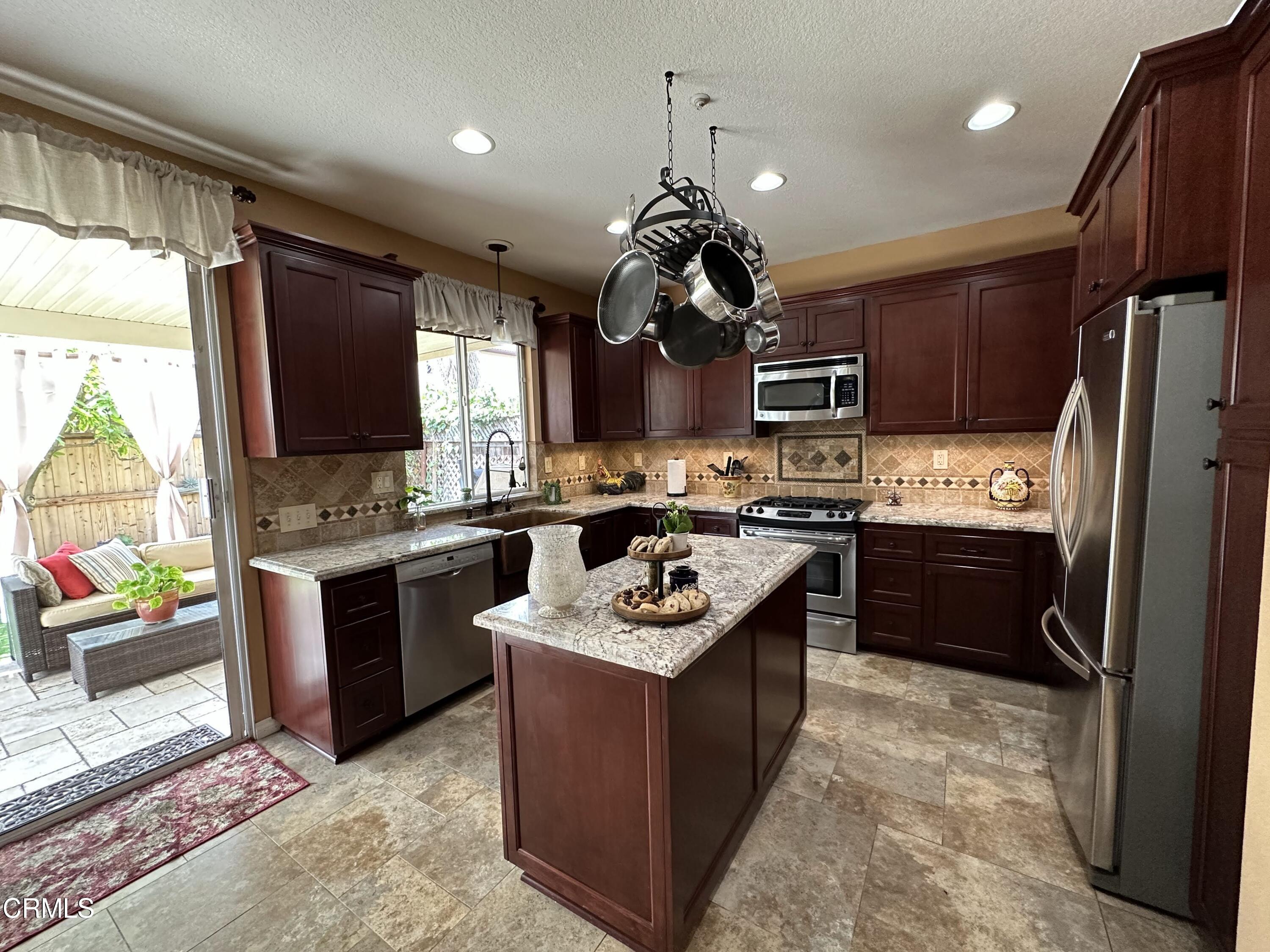 803 Noontide Way Oxnard, CA 93035 - Photo 3 of 26 a kitchen with granite countertop stainless steel appliances and wooden cabinets