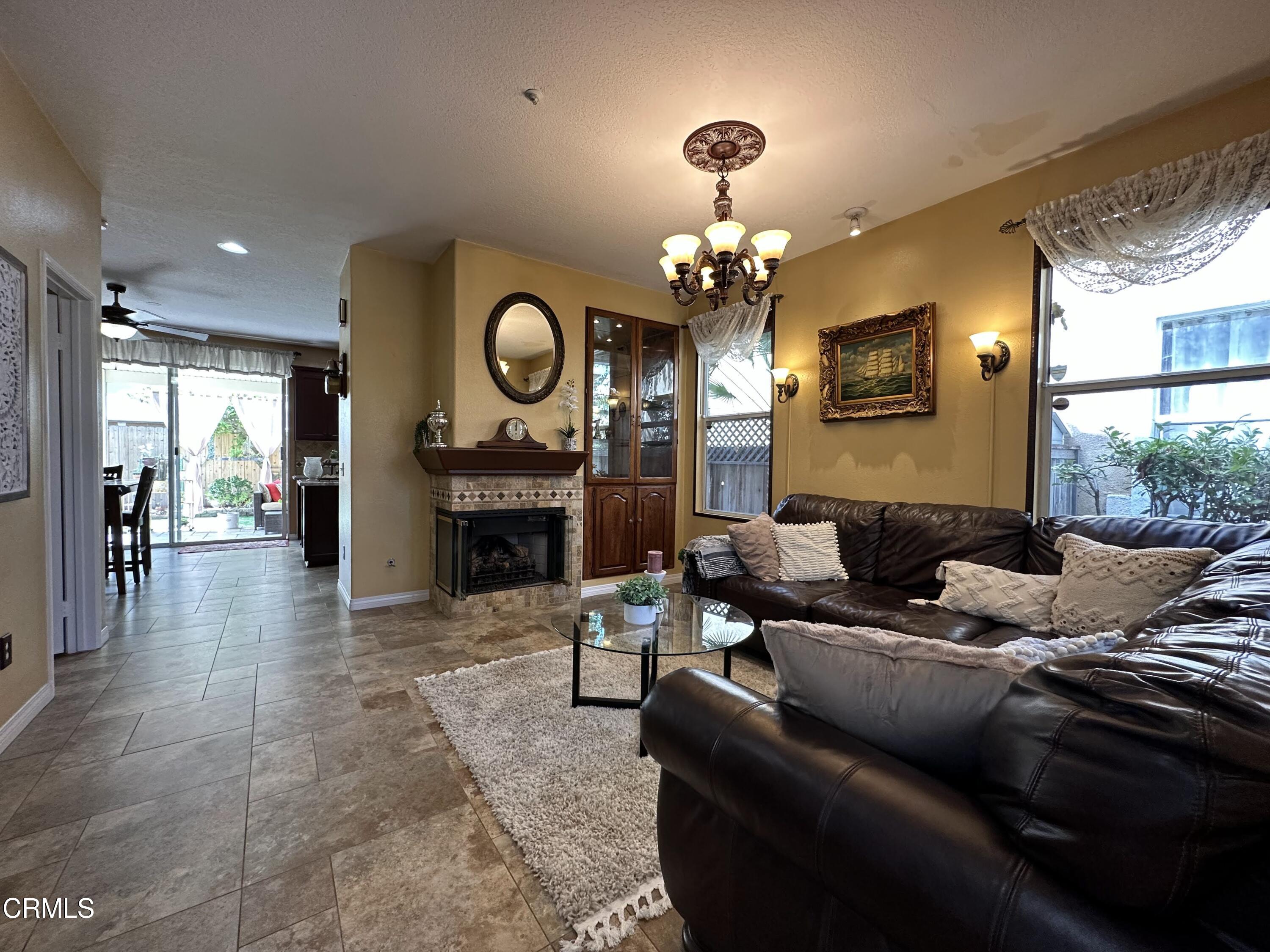 803 Noontide Way Oxnard, CA 93035 - Photo 4 of 26 a living room with furniture a large window and a fireplace