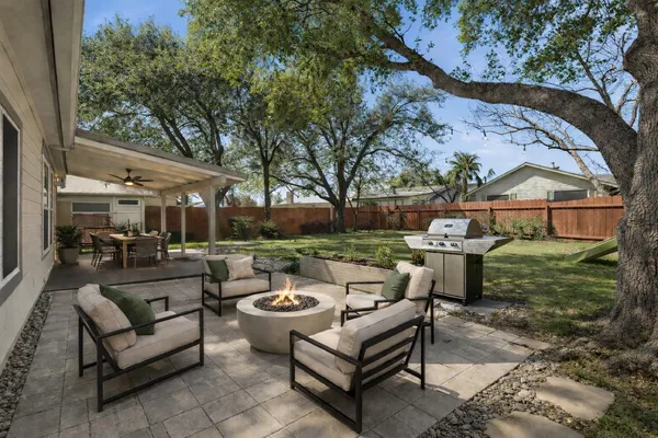 a view of a patio with couches table and chairs and potted plants