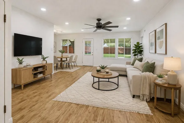 a living room with furniture a flat screen tv and a large window