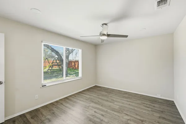 wooden floor in an empty room with a window