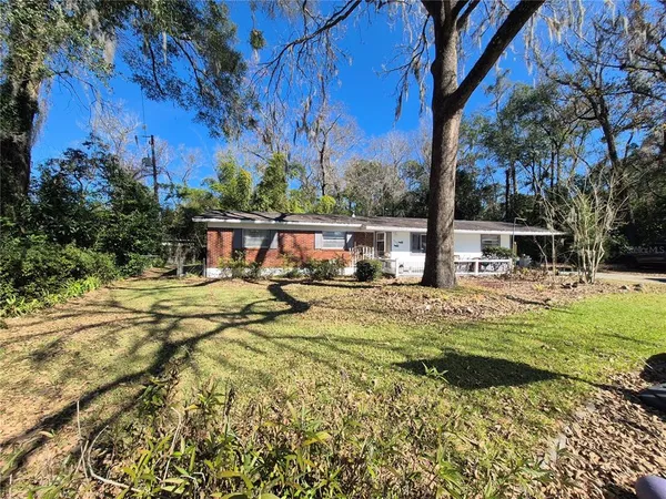 a view of swimming pool with lawn chairs and plants
