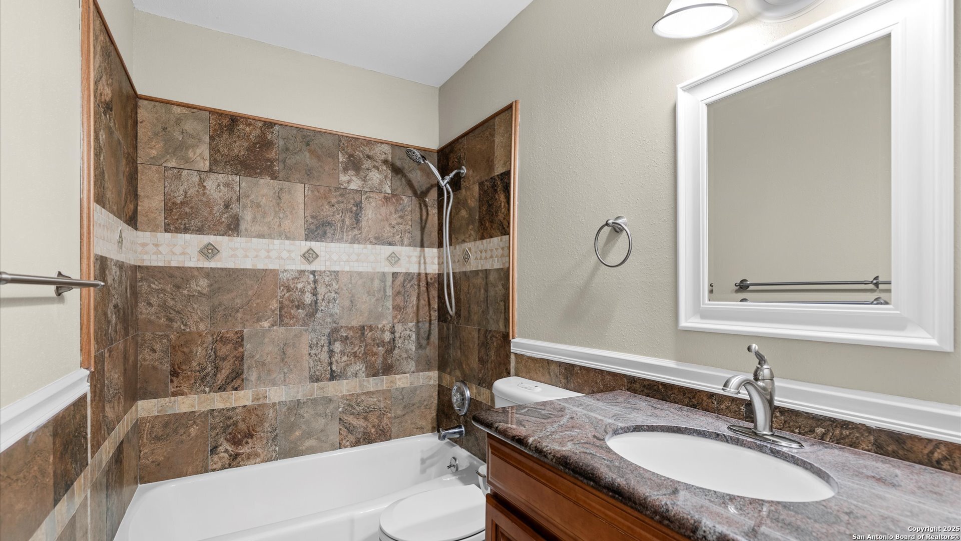 6750 Crown Ridge San Antonio, TX 78239 - Photo 18 of 31 a bathroom with a granite countertop sink a mirror and a bathtub