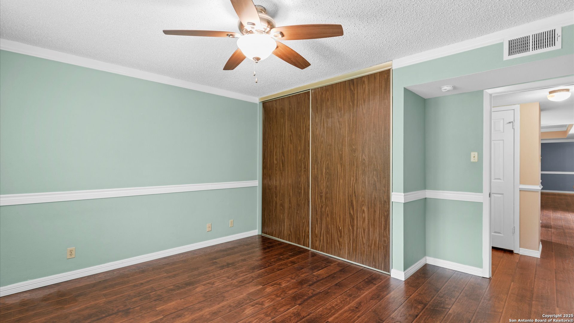 6750 Crown Ridge San Antonio, TX 78239 - Photo 19 of 31 an empty room with wooden floor chandelier fan and windows