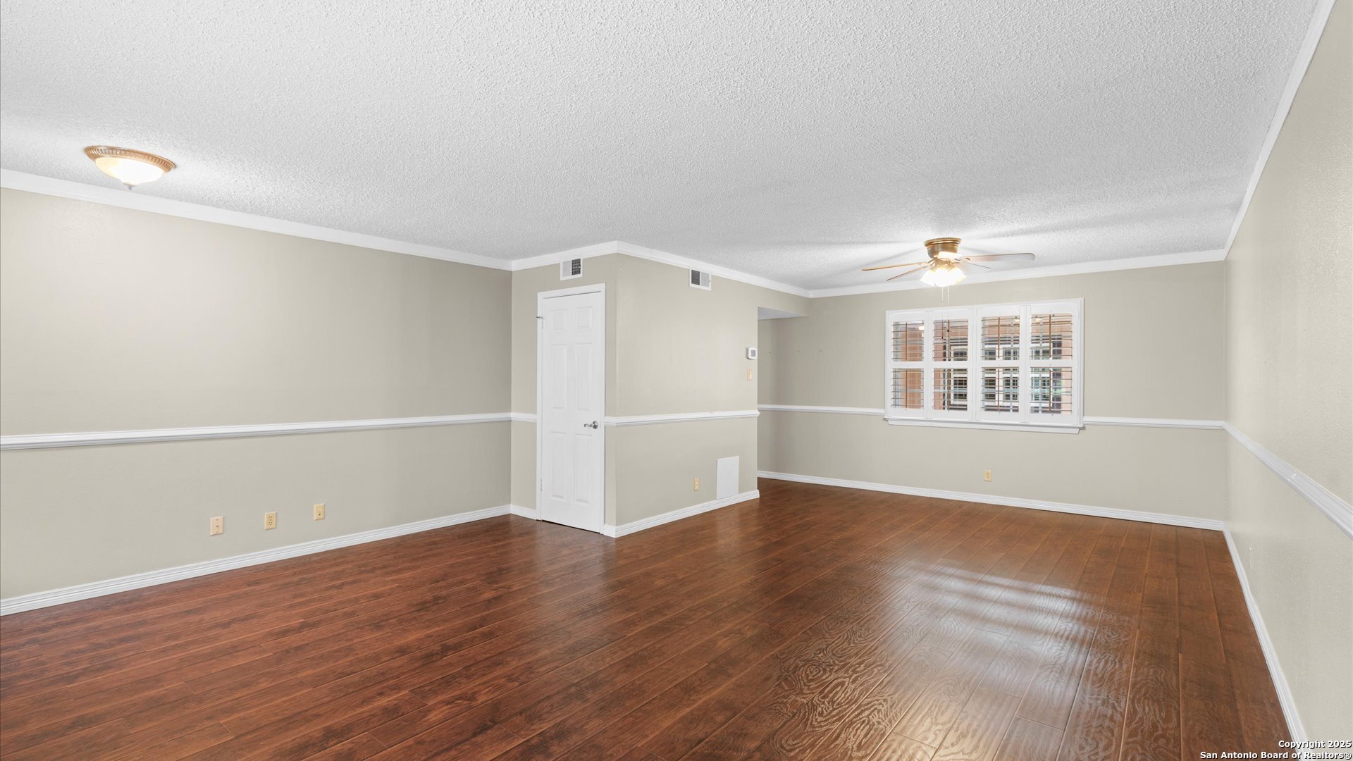 6750 Crown Ridge San Antonio, TX 78239 - Photo 5 of 31 an empty room with wooden floor cabinet and windows