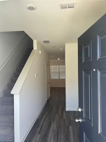 a view of hallway with stairs and wooden floor