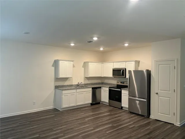 a kitchen with stainless steel appliances granite countertop a refrigerator and a stove top oven