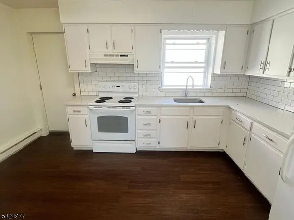 a view of kitchen with granite countertop white cabinets and white appliances