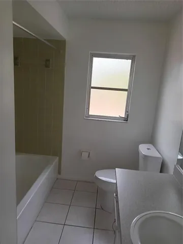a bathroom with a granite countertop sink and a bathtub