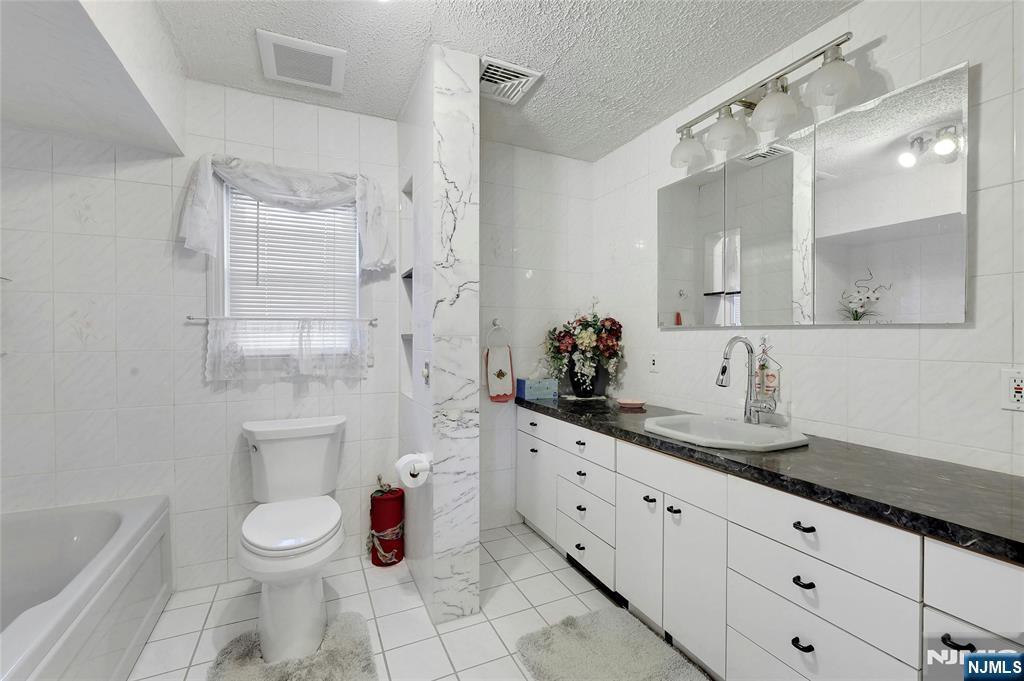 4 Highfield Court Wayne, NJ 07470 - Photo 15 of 49 a bathroom with a granite countertop sink a toilet and shower