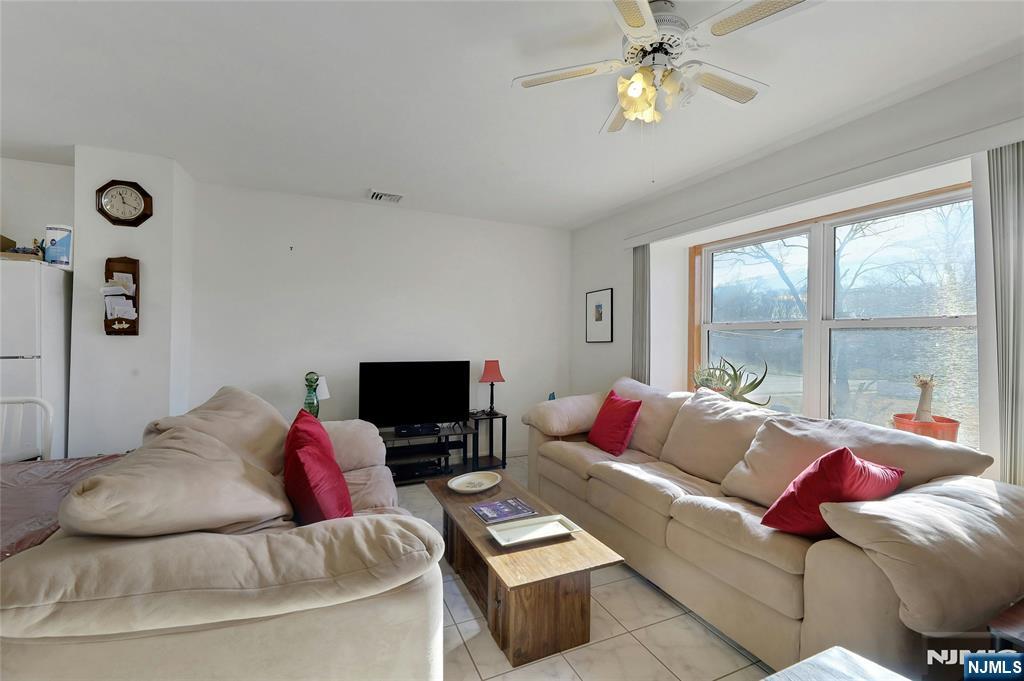 4 Highfield Court Wayne, NJ 07470 - Photo 19 of 49 a living room with furniture a large window and a flat screen tv