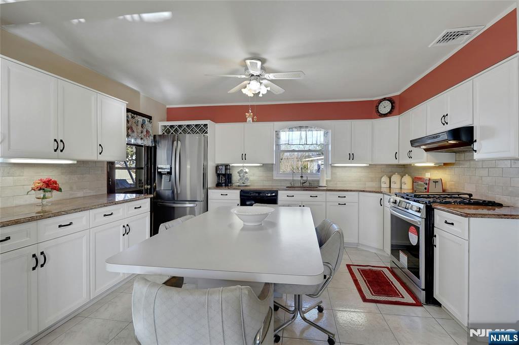 4 Highfield Court Wayne, NJ 07470 - Photo 10 of 49 a kitchen with refrigerator a stove a sink dishwasher and white cabinets with wooden floor