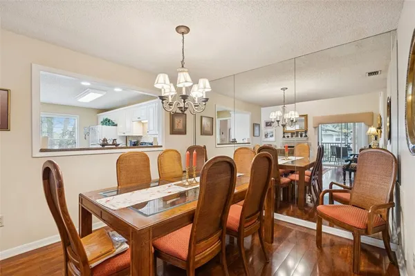 a view of a dining room and livingroom with furniture wooden floor a rug and a painting