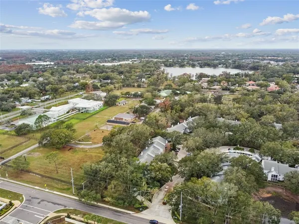 an aerial view of residential houses with outdoor space and lake view