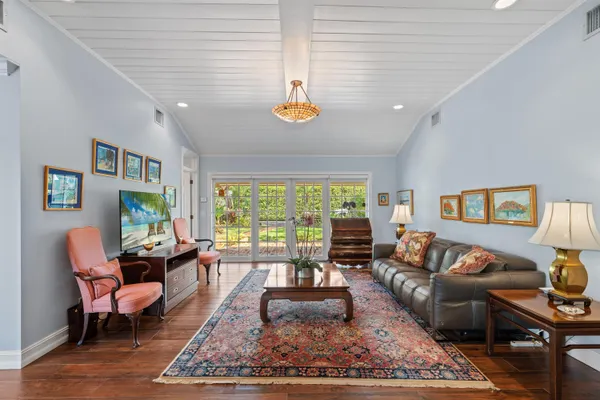 a living room with furniture floor to ceiling window and a table