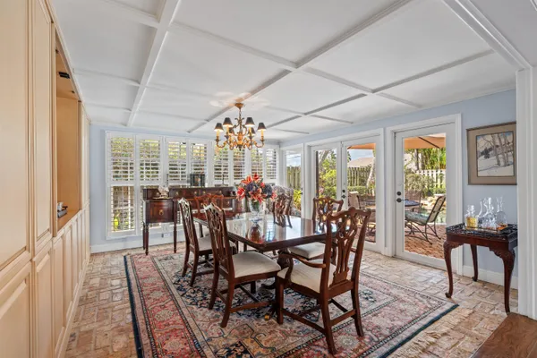 a view of a dining room with furniture a chandelier and wooden floor