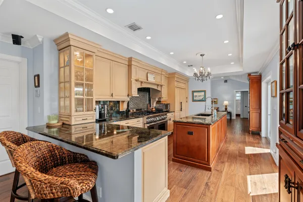 a kitchen with stainless steel appliances granite countertop sink stove top oven and cabinets