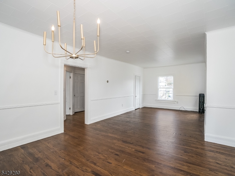 68 High Street Newton, NJ 07860 - Photo 14 of 31 an empty room with wooden floor and kitchen view