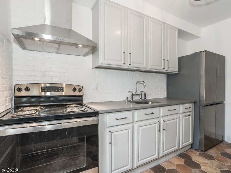 68 High Street Newton, NJ 07860 - Photo 20 of 31 a kitchen with granite countertop white cabinets and white appliances