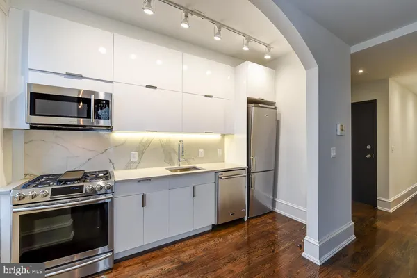 a kitchen with stainless steel appliances granite countertop a stove microwave and refrigerator