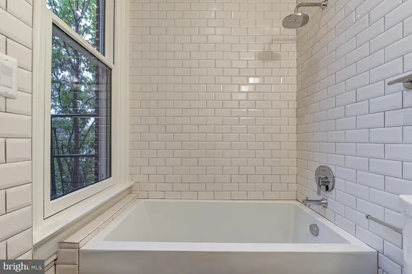 a bathroom with bathtub next to a window