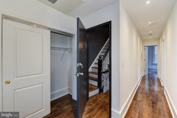 a view of a hallway with wooden floor and staircase