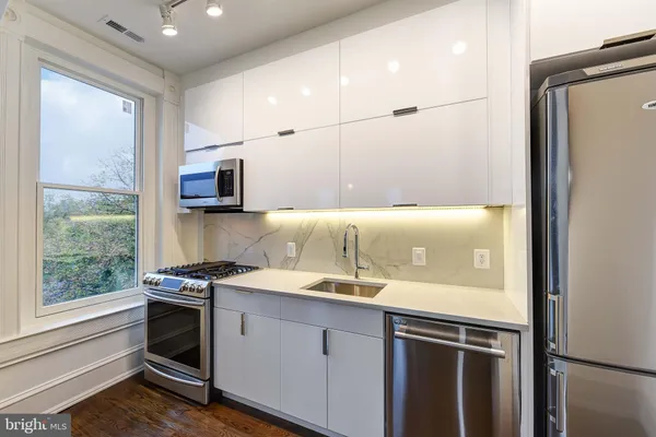 a kitchen with a sink appliances and cabinets