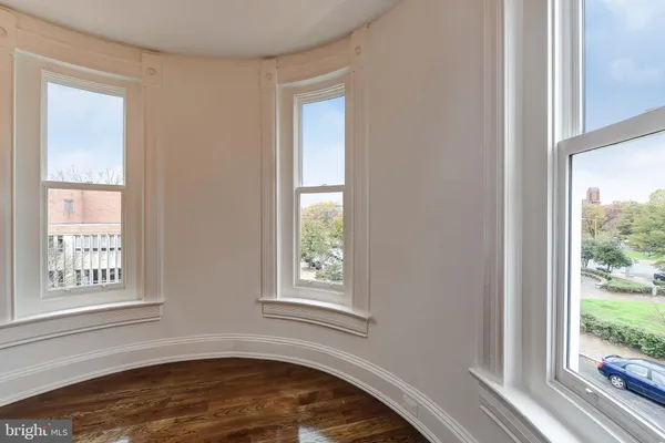 a view of a bedroom with wooden floor and a window