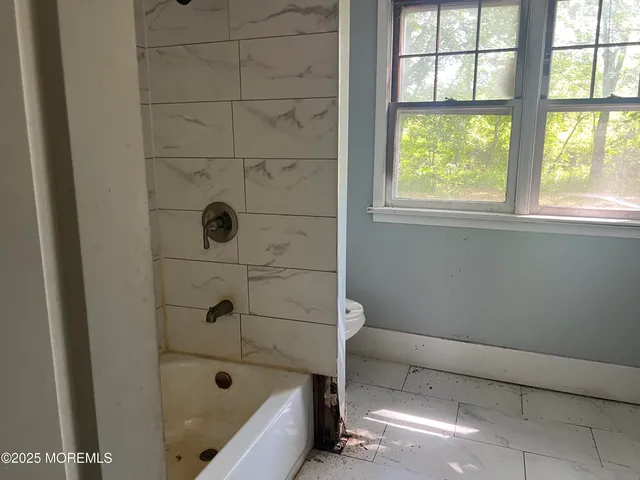 a bathroom with a bathtub and window