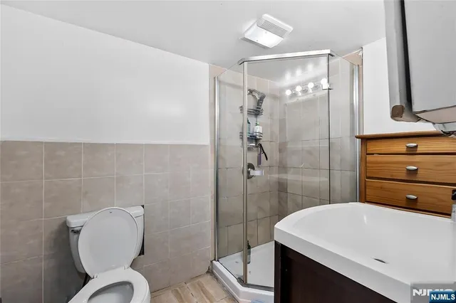 a bathroom with a sink a toilet and shower