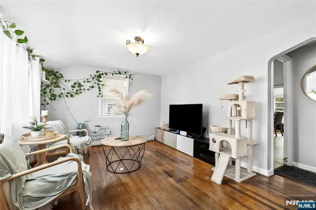 a living room with furniture a flat screen tv and a floor to ceiling window