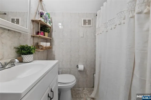 a bathroom with a sink a toilet and shower curtain
