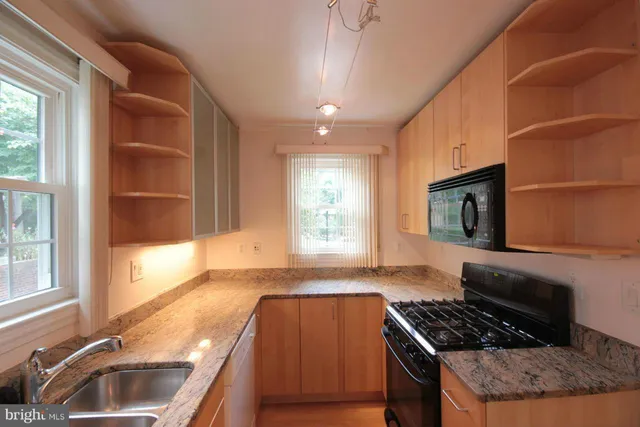 a kitchen with granite countertop a stove and a sink