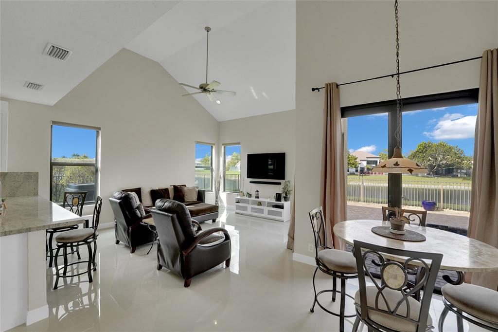 22280 Tupelo Place Boca Raton, FL 33428 - Photo 20 of 53 a living room with furniture a flat screen tv and a large window