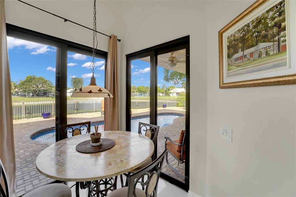 22280 Tupelo Place Boca Raton, FL 33428 - Photo 21 of 53 a view of a dining room with furniture wooden floor and a large window
