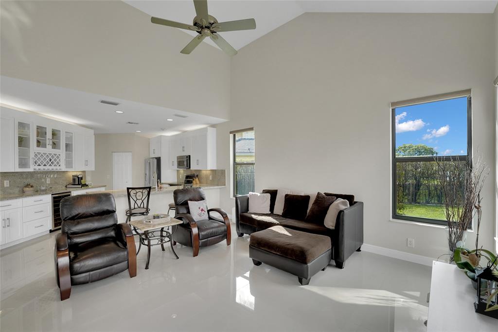 22280 Tupelo Place Boca Raton, FL 33428 - Photo 26 of 53 a living room with furniture a ceiling fan and a window