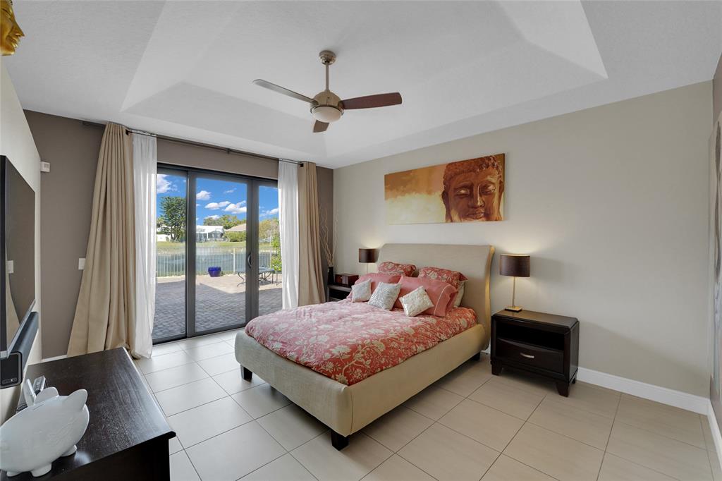 22280 Tupelo Place Boca Raton, FL 33428 - Photo 31 of 53 a bedroom with a bed and a chandelier