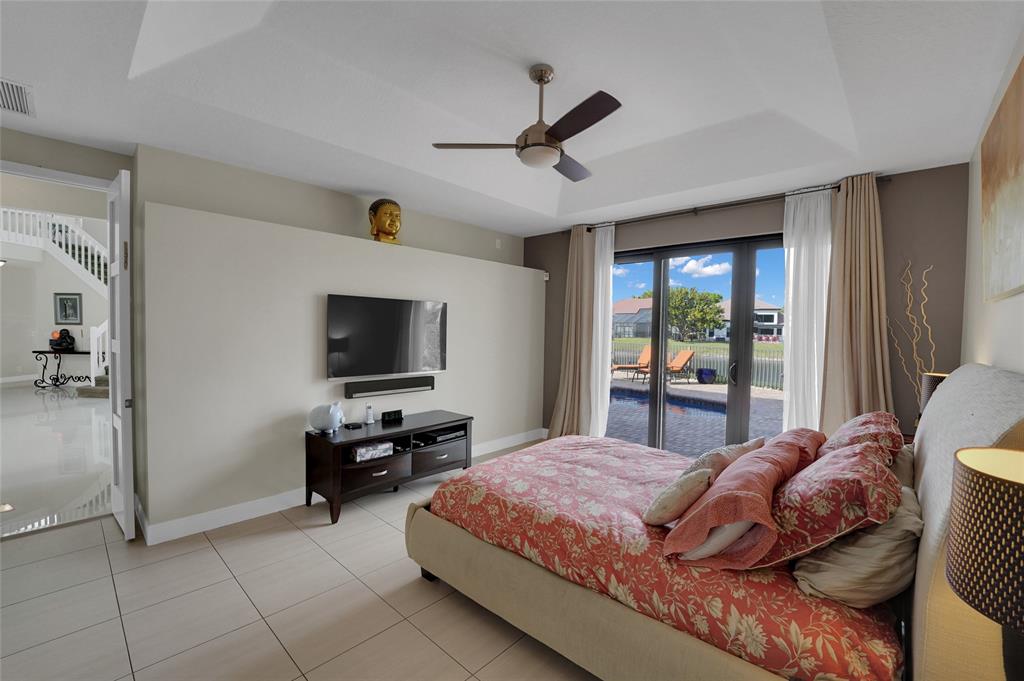 22280 Tupelo Place Boca Raton, FL 33428 - Photo 32 of 53 a bedroom with a bed and a flat screen tv